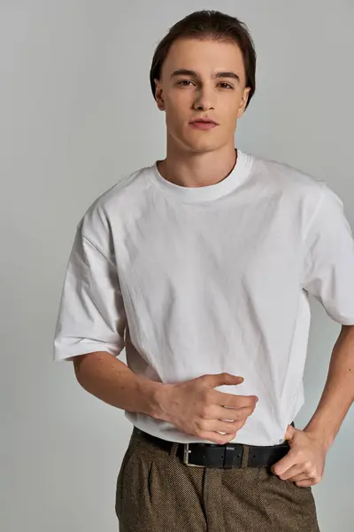 Young sophisticated man in elegant attire with brown pants posing and looking at camera — Stock Photo