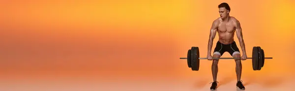 Young shirtless sporty man in black pants exercising with barbell on vibrant orange backdrop, banner — Stock Photo