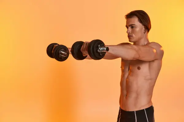 Attractive muscular shirtless man in black sport shorts training with dumbbells on vivid backdrop — Stock Photo