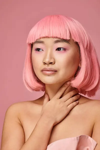 Porträt einer hübschen jungen Asiatin mit rosafarbenen Haaren, die vor lebendigem Hintergrund zur Seite schaut — Stockfoto