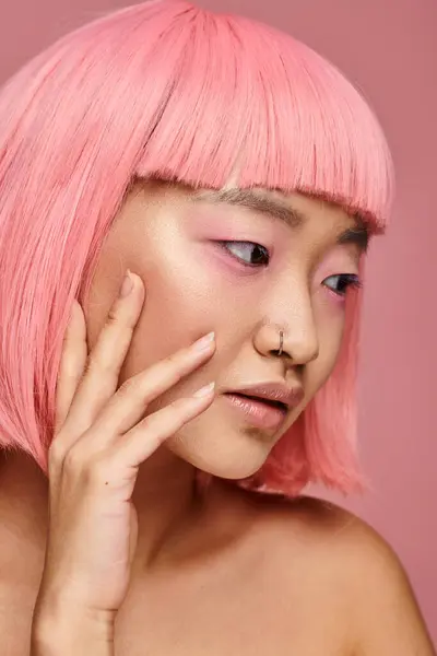 Retrato de mulher bonita com cabelo rosa olhando para o lado e tocando sua bochecha no fundo vibrante — Fotografia de Stock