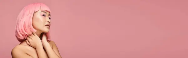 Horizontal shot of asian woman with pink hair touching neck with hands on vibrant background — Stock Photo