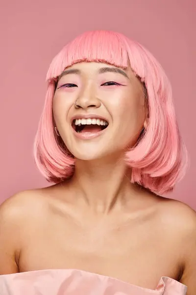 Jolie jeune femme aux cheveux roses et maquillage riant sur fond vibrant — Photo de stock
