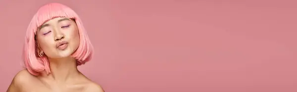 Banner de mulher bonita com cabelo rosa e maquiagem beijos de ar com olhos fechados em fundo vibrante — Fotografia de Stock
