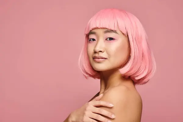 Suave asiático joven chica con piercing en la nariz, rosa pelo y maquillaje contra vibrante fondo - foto de stock