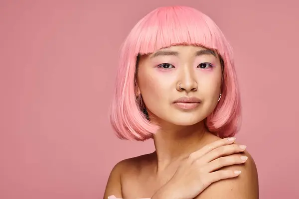 Красивая женщина в возрасте 20 лет с розовыми волосами и пронзительным носом трогательное плечо на ярком фоне — стоковое фото