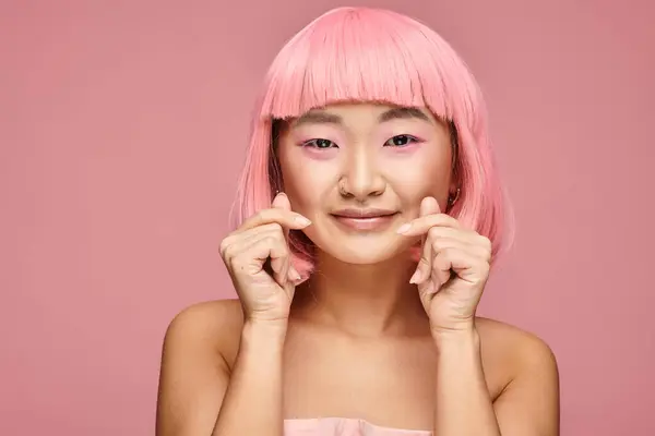 Belle asiatique jeune femme avec rose cheveux montrant avec mains coeur signe sur fond vibrant — Photo de stock
