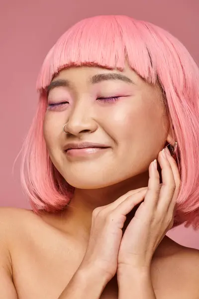 Attrayant jeune fille avec les cheveux roses et le maquillage fermer les yeux et sourire sur fond vibrant — Photo de stock