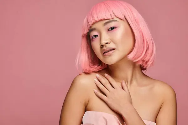 Bella giovane donna asiatica con naso piercing toccante per clavicola contro sfondo vibrante — Foto stock