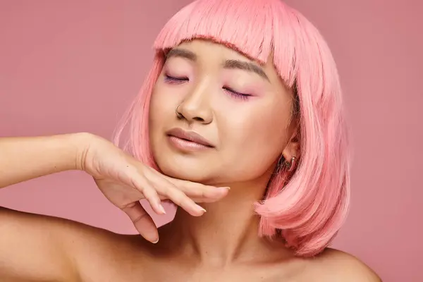 Attraente asiatico donna in il suo 20s con chiuso occhi toccare per mento con mano su vibrante sfondo — Foto stock