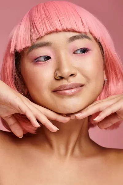 Закрыть милую женщину с розовым макияжем, смотрящую в сторону на оживленном фоне — стоковое фото