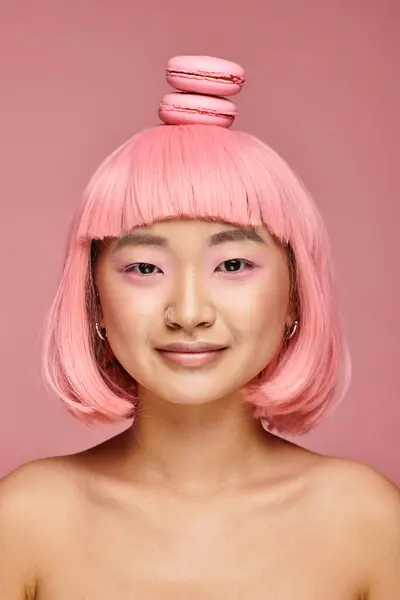 Портрет привлекательный молодой женщины с розовыми волосами и макаронами на голове на ярком фоне — стоковое фото