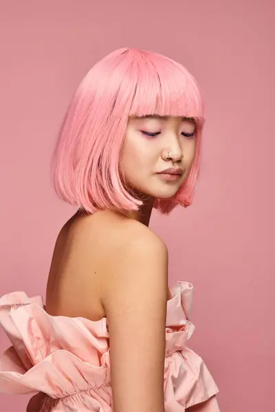 Seducente asiatico giovane donna con rosa capelli e top posa e guardando verso il basso in vibrante sfondo — Foto stock