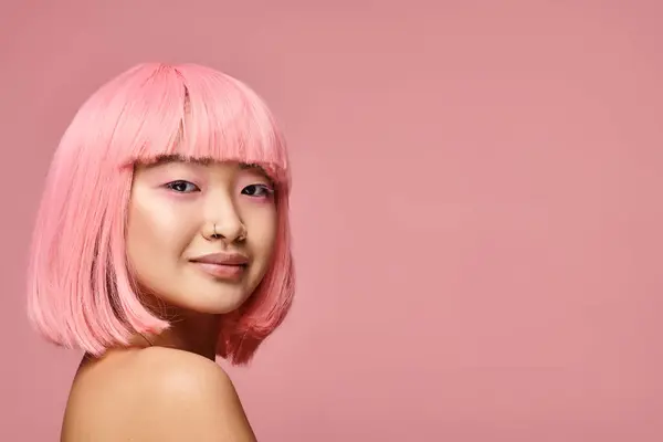 Счастливая азиатская девушка в свои 20 лет с пирсингом носа, розовые волосы и макияж улыбаясь на ярком фоне — стоковое фото