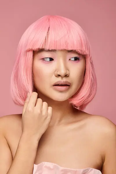 Lindo asiático joven chica con nariz piercing tocando a pelo y mirando a lado en vibrante fondo - foto de stock