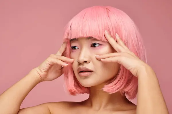 Profilo di bella donna asiatica negli anni '20 con i capelli rosa in posa con le mani sullo sfondo vibrante — Foto stock