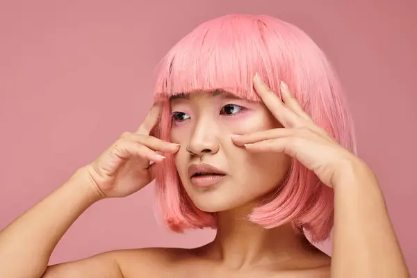 Profile of beautiful asian woman in 20s with pink hair posing with hands against vibrant background — Stock Photo