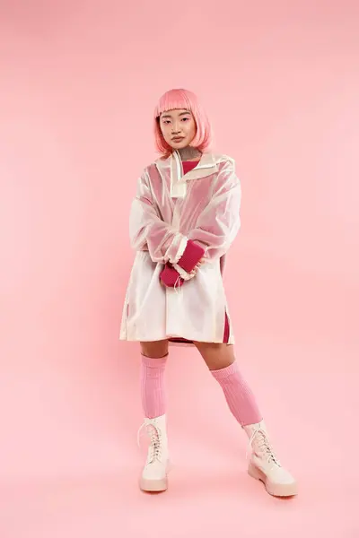 Atraente asiático jovem mulher com rosa cabelo e maquiagem no elegante roupa contra vibrante fundo — Fotografia de Stock
