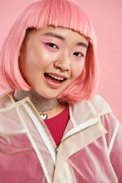 Retrato de linda mujer joven asiática con collar de plata, pelo rosa y maquillaje sobre un fondo vibrante - foto de stock