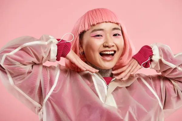 Happy asian woman in her 20s with pink hair and makeup smiling with hands on vibrant background — Stock Photo