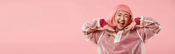 Знамя милой азиатской женщины с розовыми волосами и макияжем счастливо улыбаясь руками на ярком фоне — стоковое фото