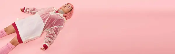 Banner of young woman with silver necklace, pink hair and makeup lying down on vibrant background — Stock Photo