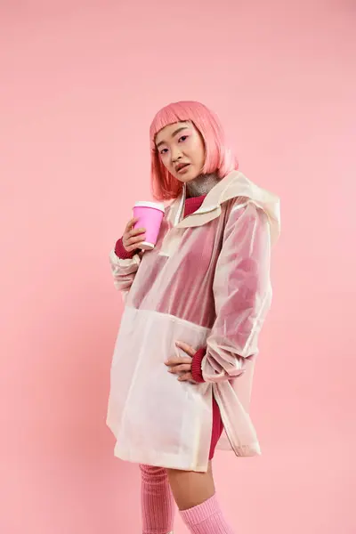 Bonita asiático jovem mulher com rosa cabelo posando com café xícara no vibrante fundo — Fotografia de Stock