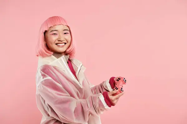 Allegro asiatico giovane donna in elegante vestito felice sorridente con joystick su vibrante sfondo — Foto stock