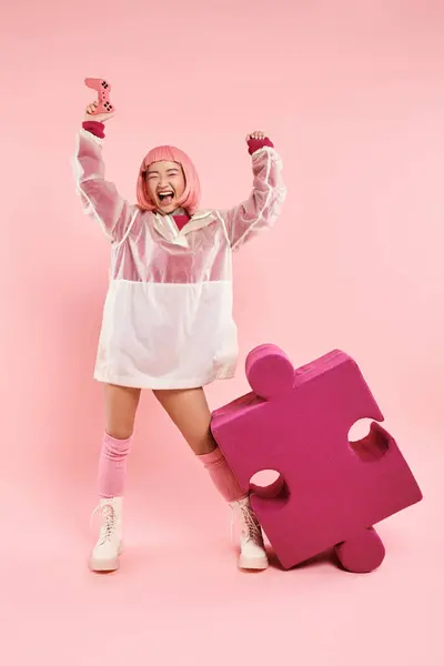 Happy asian woman in 20s in stylish outfit playing to joystick and wining on vibrant background — Stock Photo