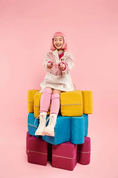 Allegra ragazza asiatica con i capelli rosa seduto su grandi puzzle e giocare su sfondo vibrante — Foto stock