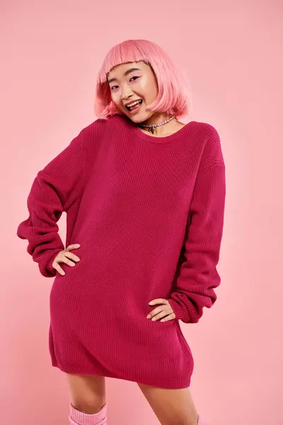 Schöne asiatische Frau mit rosa Haaren und Make-up in stilvollem Outfit posiert vor lebendigem Hintergrund — Stockfoto