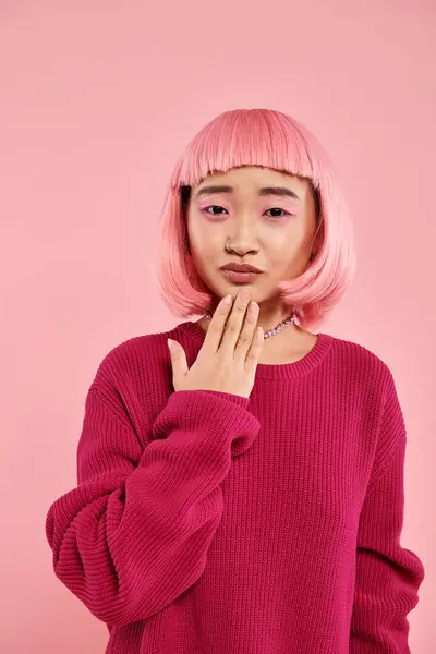 Hermosa mujer joven asiática con pelo rosa y collar de perlas en suéter vibrante simpatizante - foto de stock
