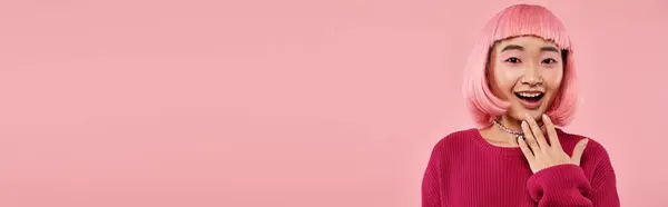 Банер азіатської дівчини в яскравому светрі з перловим намистом, що виражає захоплення на рожевому фоні — стокове фото