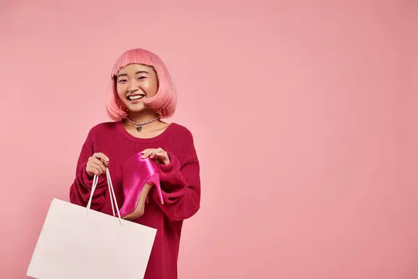 Feliz sonriente asiático joven mujer tirando fuera un par de flamante botas en compras paquete - foto de stock