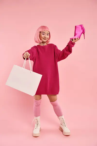 Encantador mulher asiática em seus 20s com feliz sorrindo orgulhoso de sua compra no fundo rosa — Fotografia de Stock