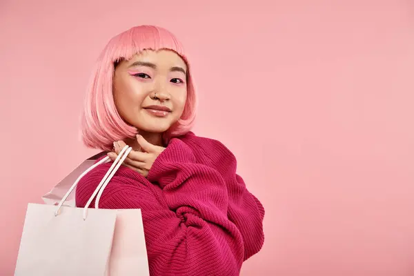 Lovely asian woman in 20s with pink hair and makeup posing with packets against vibrant background — Stock Photo