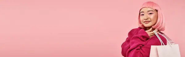 Horizontal view of attractive asian woman in 20s posing with packets against pink background — Stock Photo