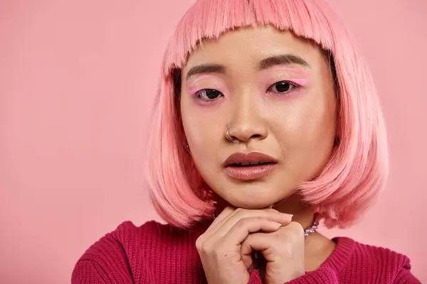 Закрыть азиатскую женщину 20 лет с розовым макияжем и сложенными руками на ярком фоне — стоковое фото