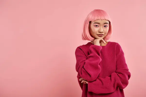 Confident asian girl with pink hair in big jumper supporting chin with hand on vibrant background — Stock Photo