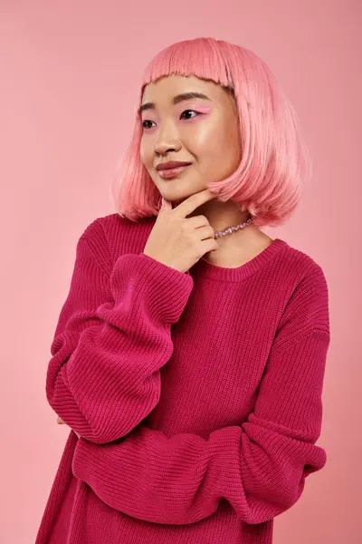Приваблива молода жінка з рожевим підборіддям для волосся з рукою на яскравому фоні — стокове фото