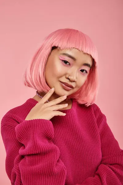 Мила азіатська дівчина з рожевим волоссям, що нахиляє голову, усміхнений і зворушливий підборіддя на яскравому фоні — стокове фото