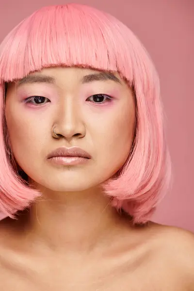 Beautiful young woman with pink hair looking to down against vibrant background — Stock Photo