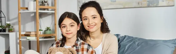 A woman and a little girl sitting together on a cozy couch, enjoying quality time at home. — Stock Photo