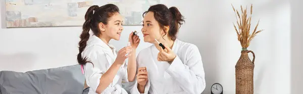 A brunette mother and daughter standing side by side in white bath robes, showcasing their close bond and connection. — Stock Photo