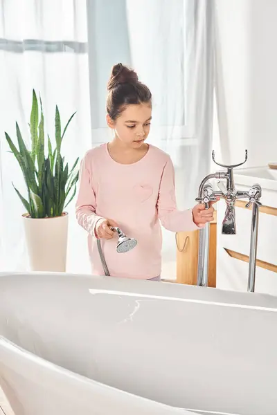 Una ragazza bruna si trova di fronte a un lavandino in un bagno moderno, impegnandosi nella routine di bellezza e igiene. — Foto stock
