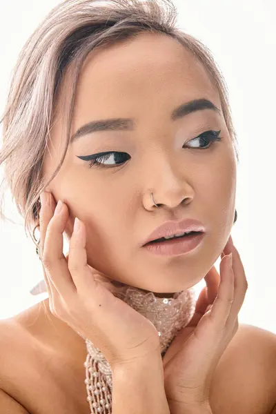 Закрыть привлекательную азиатскую молодую женщину с элегантными рамками макияжа вокруг лица с руками — стоковое фото
