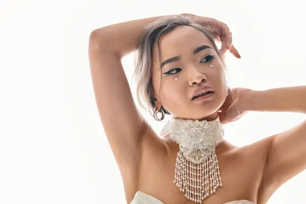 Приваблива азіатська молода жінка з елегантним макіяжем дивиться на бік і кладе руки за голову — стокове фото