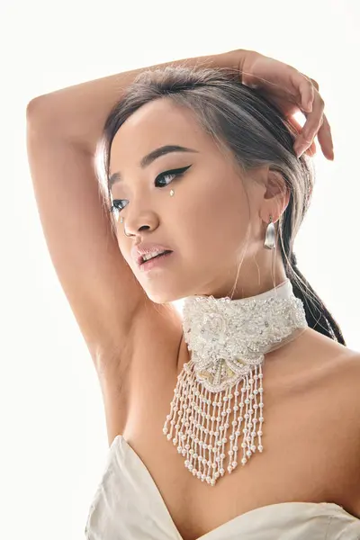 Профиль элегантной азиатской молодой женщины с изяществом макияжа глядя в сторону и положить руки за голову — стоковое фото