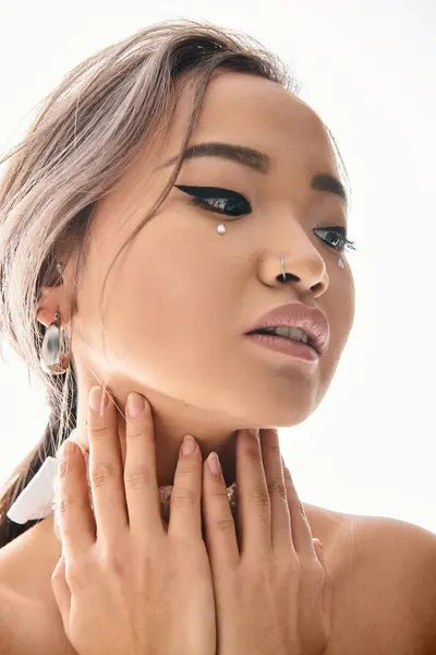 Primer plano de hermosa novia asiática con aspecto de maquillaje elegante al lado y abrazo cuello con las manos - foto de stock