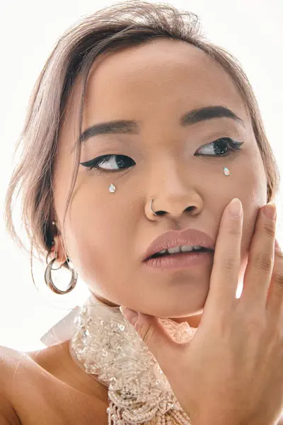 Close up elegante Frau mit Anmut Make-up zarte Berührung auf die Wange mit der Hand auf hellem Hintergrund — Stockfoto